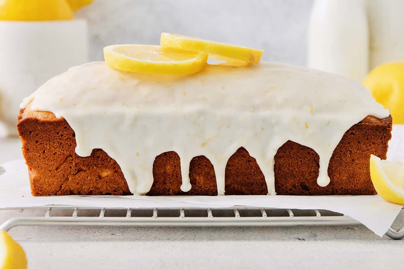 A lemon pound cake stopped with glaze and lemon slices.