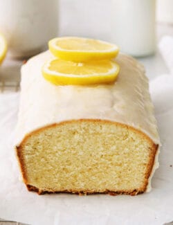 A lemon pound cake stopped with glaze and lemon slices.
