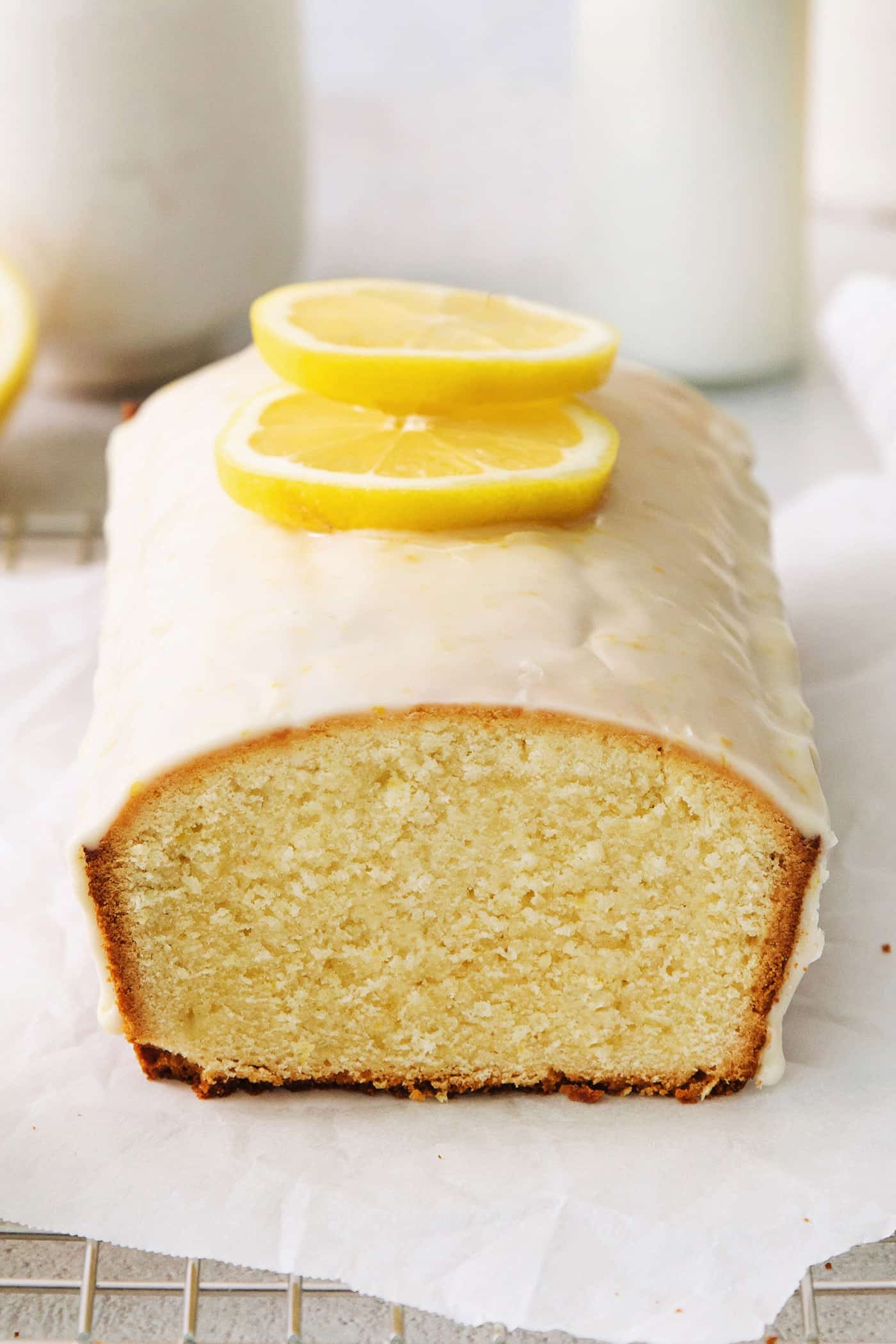 A lemon pound cake stopped with glaze and lemon slices.