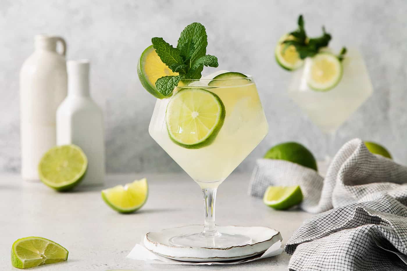 Classic mojitos are shown in glasses topped with mint and lime.