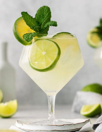 Classic mojitos are shown in glasses topped with mint and lime.