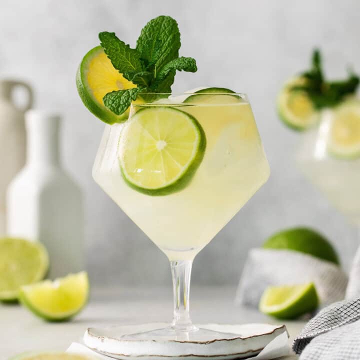 Classic mojitos are shown in glasses topped with mint and lime.
