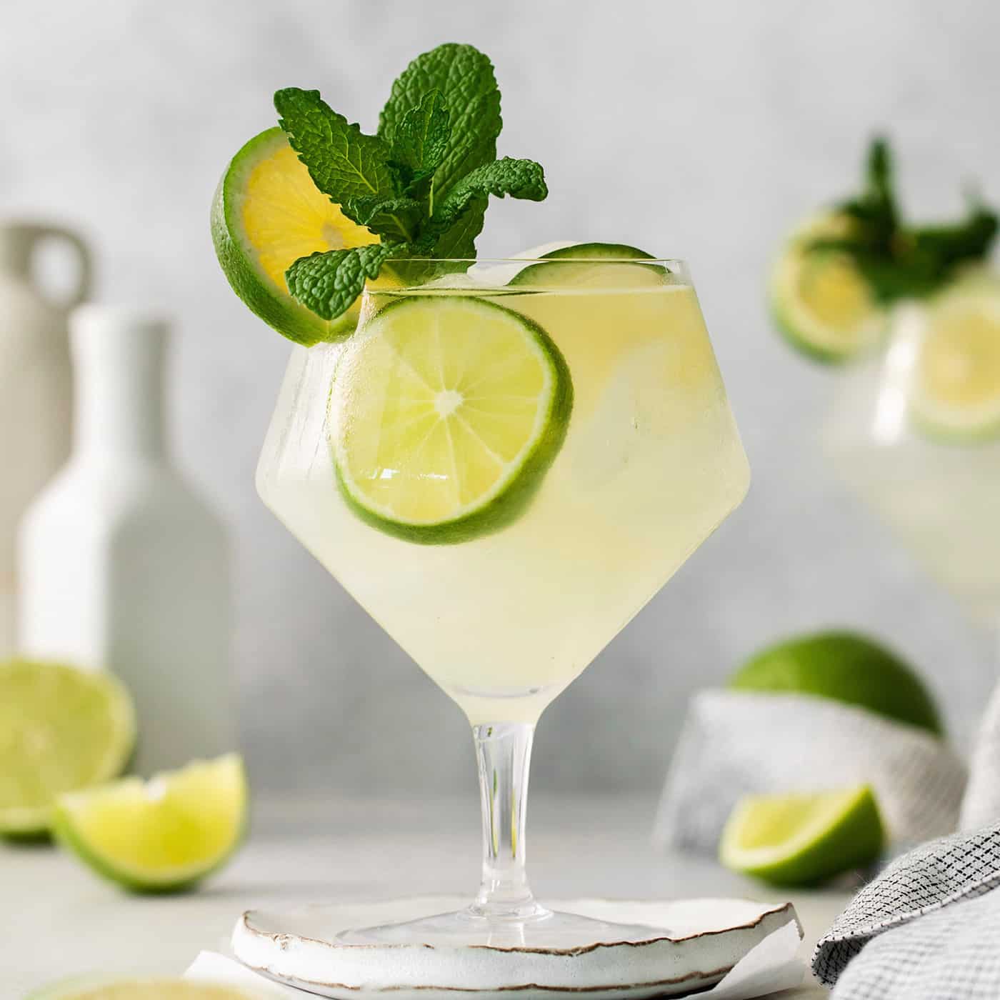 Classic mojitos are shown in glasses topped with mint and lime.