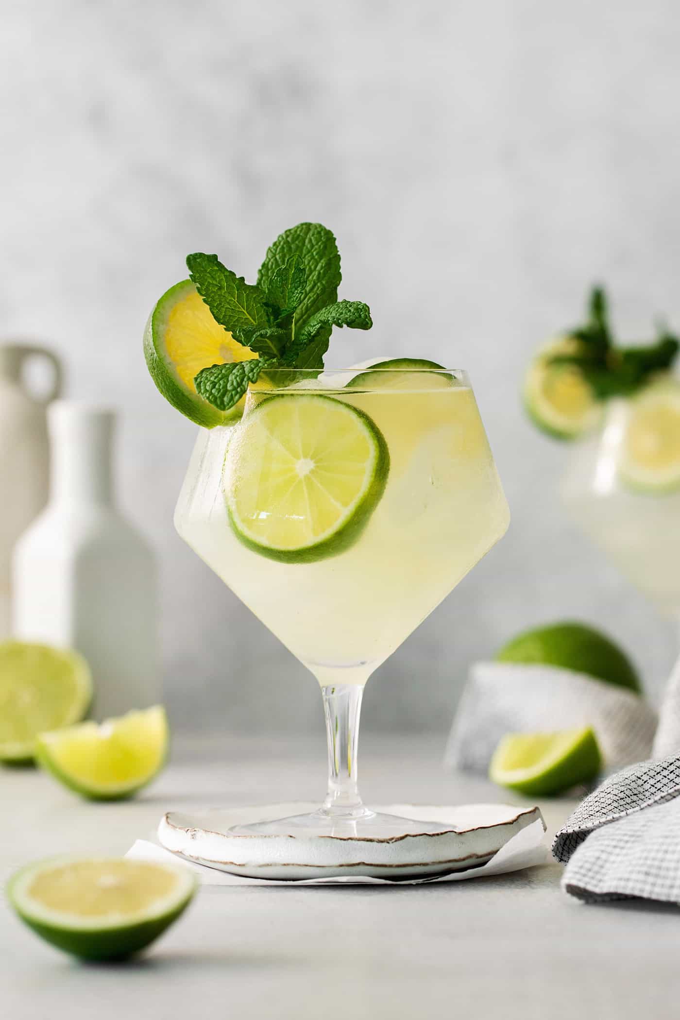 Classic mojitos are shown in glasses topped with mint and lime.