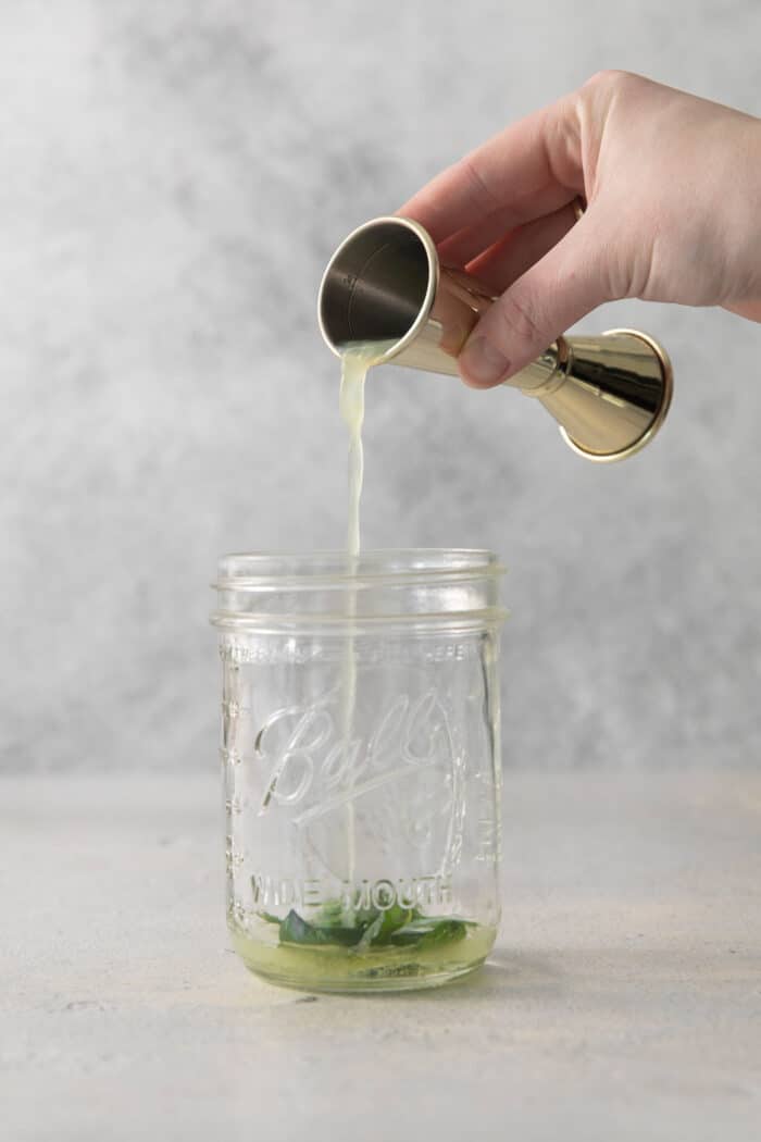 Simple syrup is added to a jar.