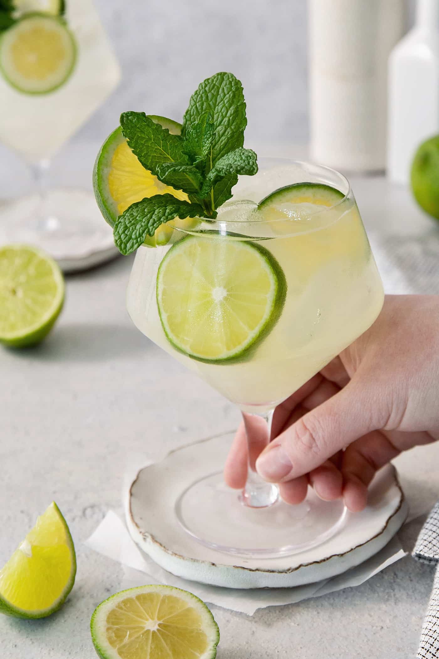 A hand holds a glass of mojito.