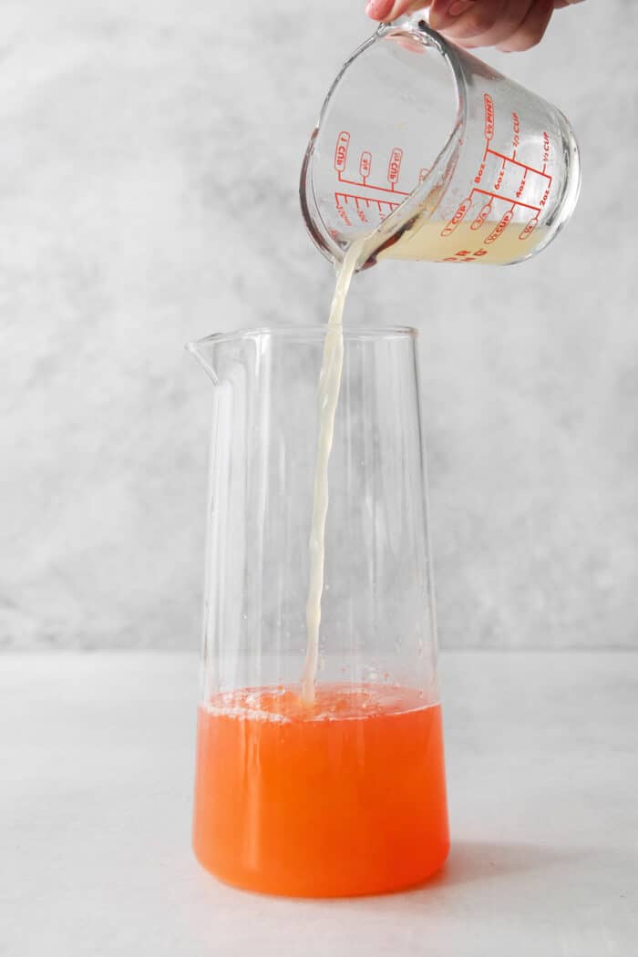 pouring lime juice into a pitcher