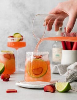 pouring a rhubarb margarita mix into a glass