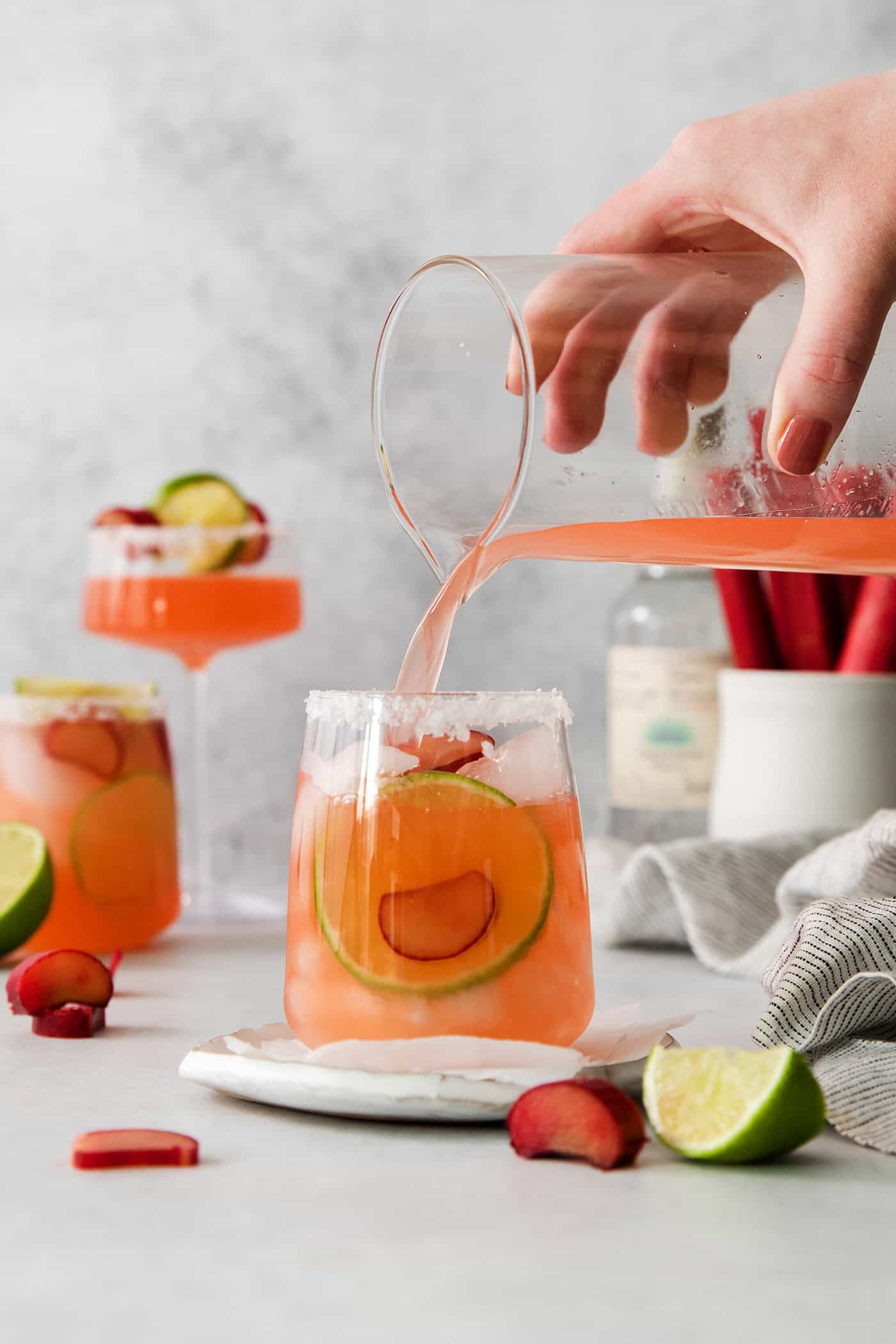 pouring a rhubarb margarita mix into a glass