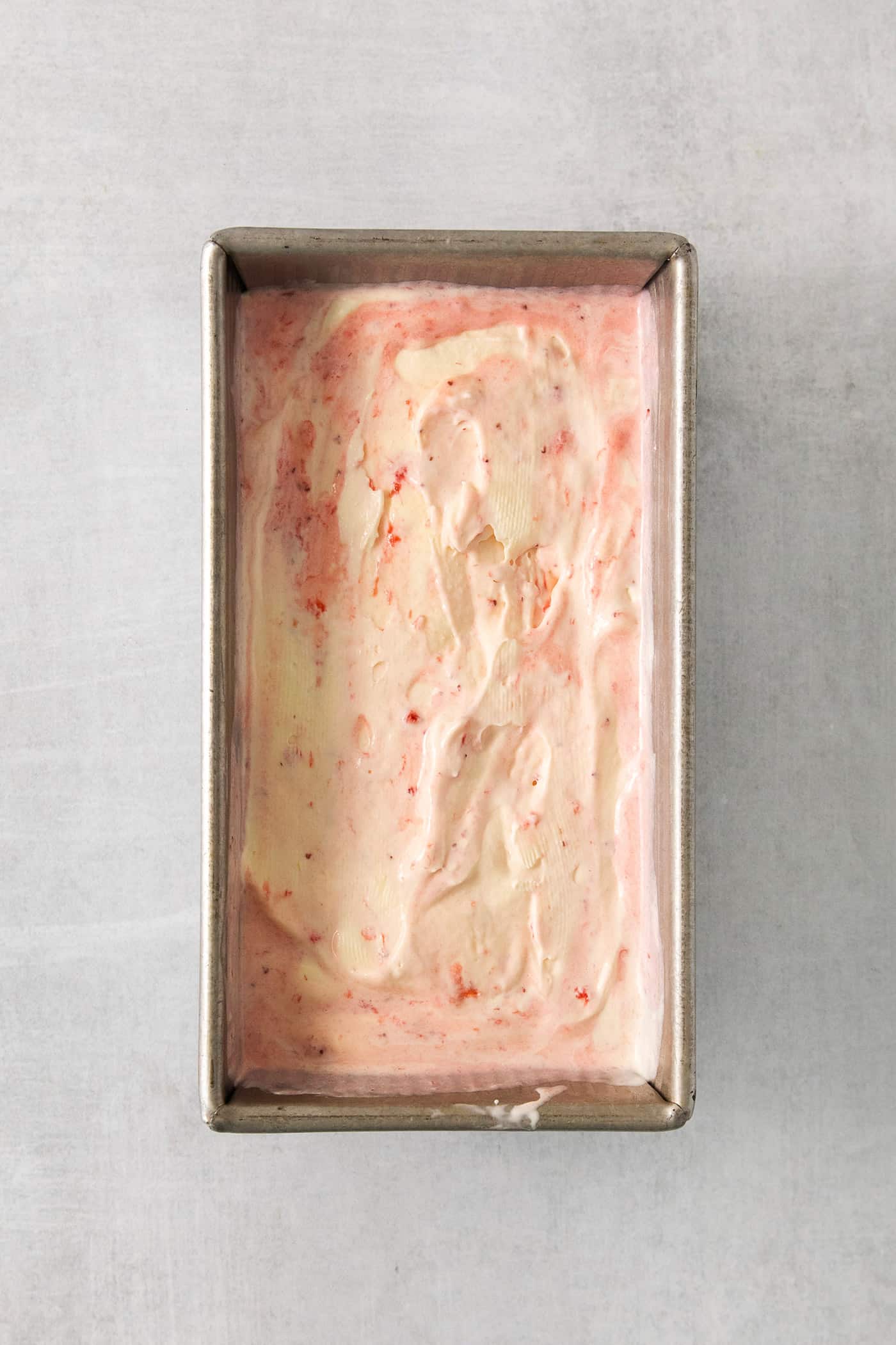 Crème fraîche strawberry swirl ice cream in a loaf pan.