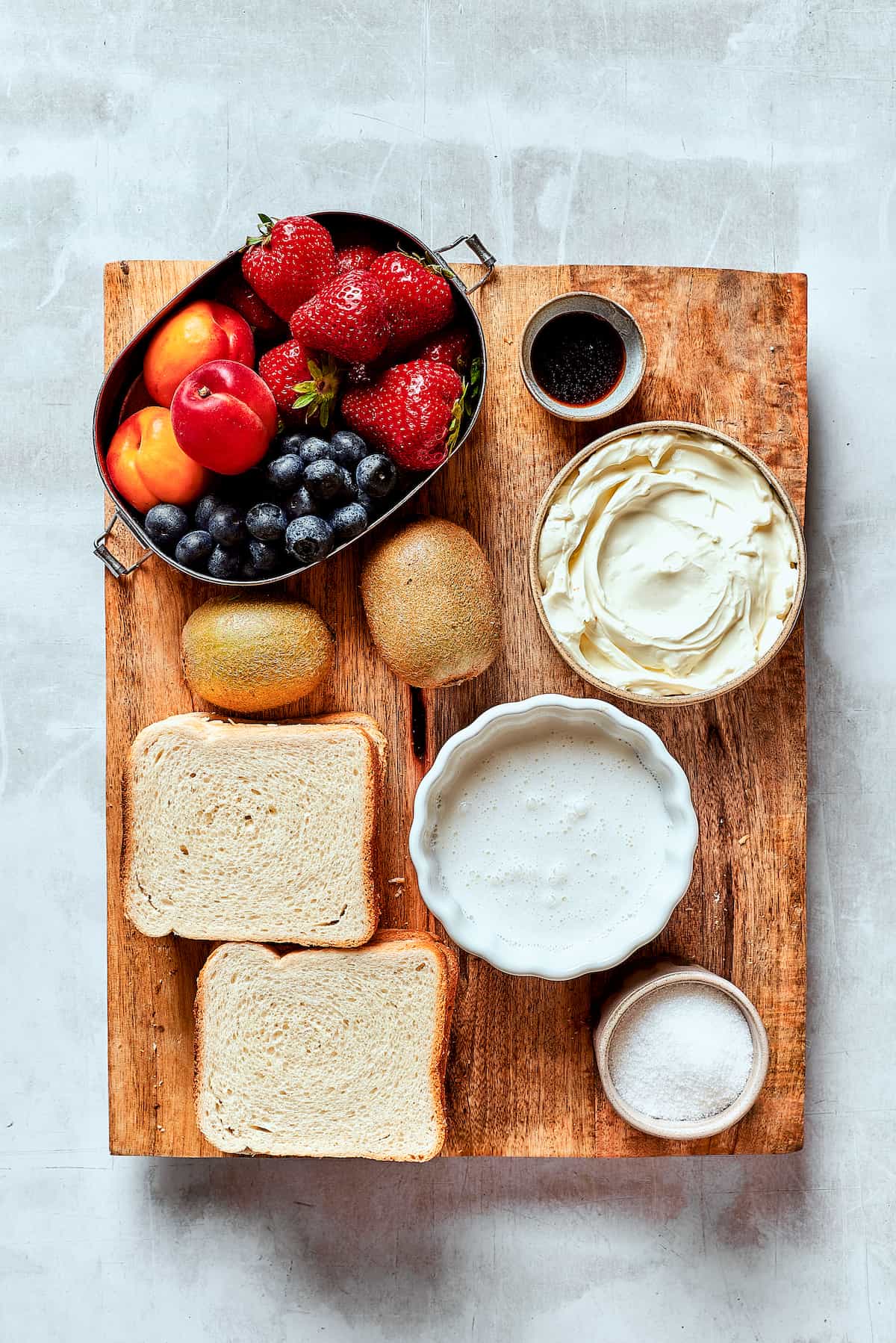 Ingredients needed to make fruit sand: fruit, white bread, cream cheese, whipped cream, sugar, vanilla.