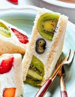 Slices of fruit sando on a plate with a fork.