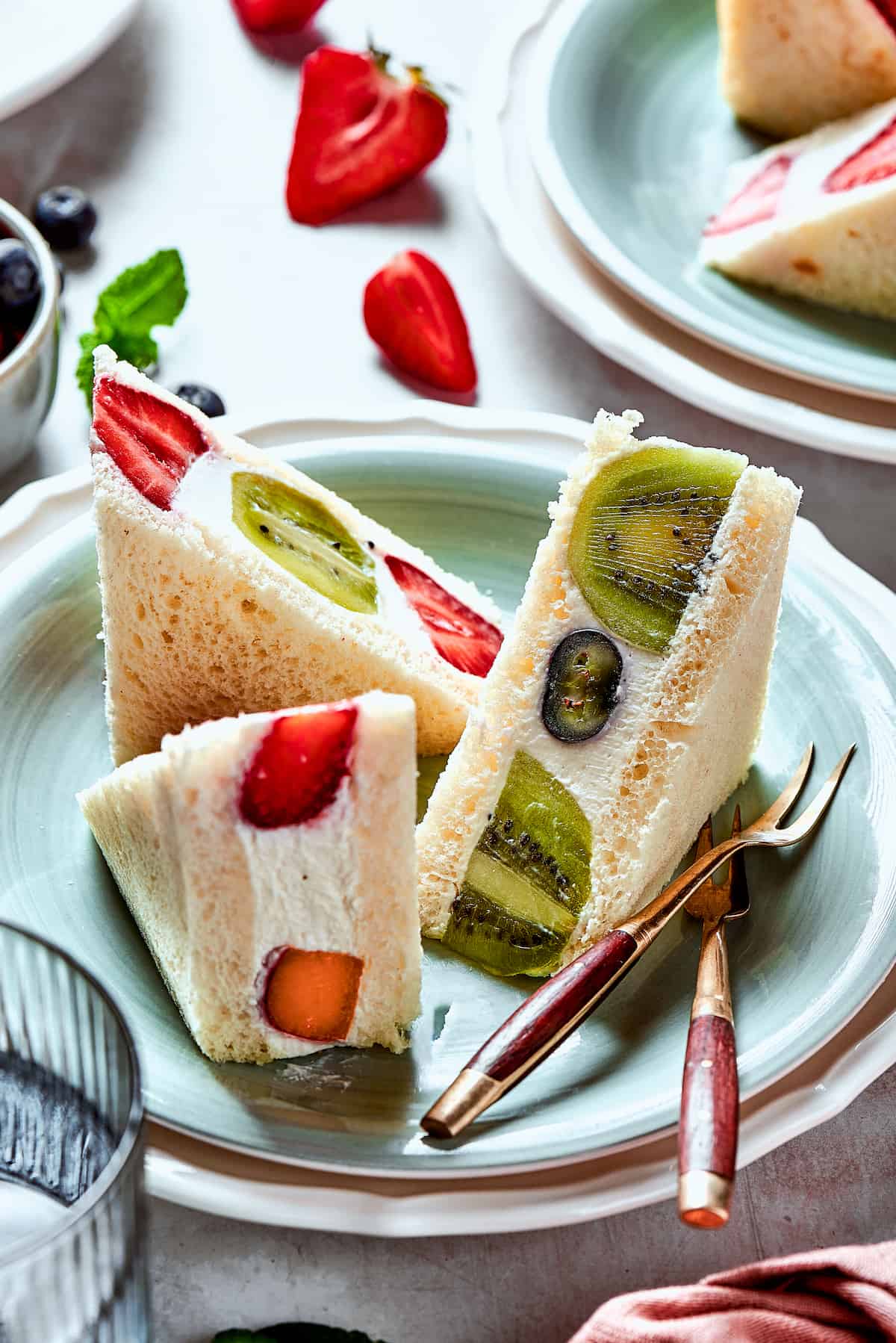 Slices of fruit sando on a plate with a fork.