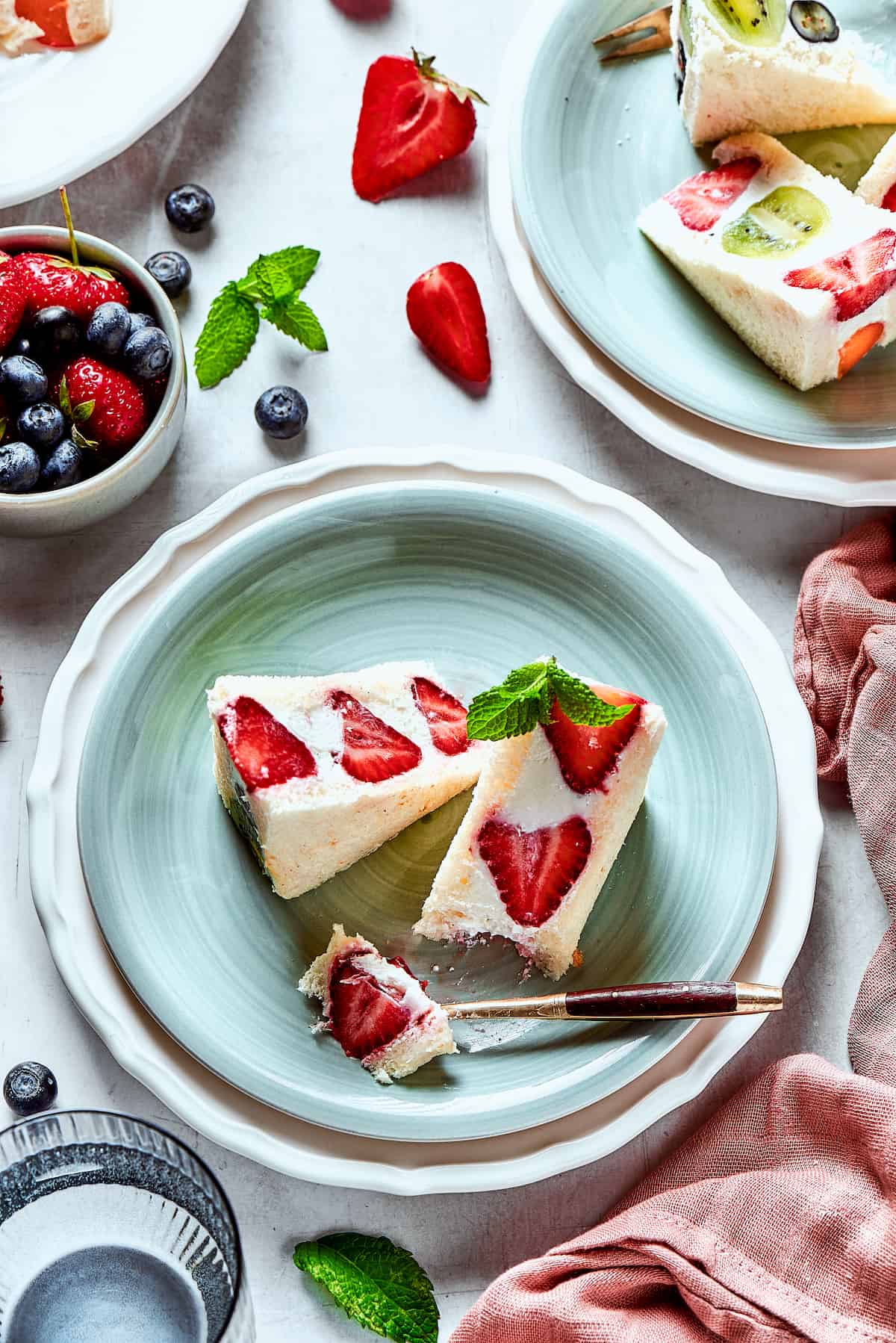 Slices of fruit sando on a plate with a fork.