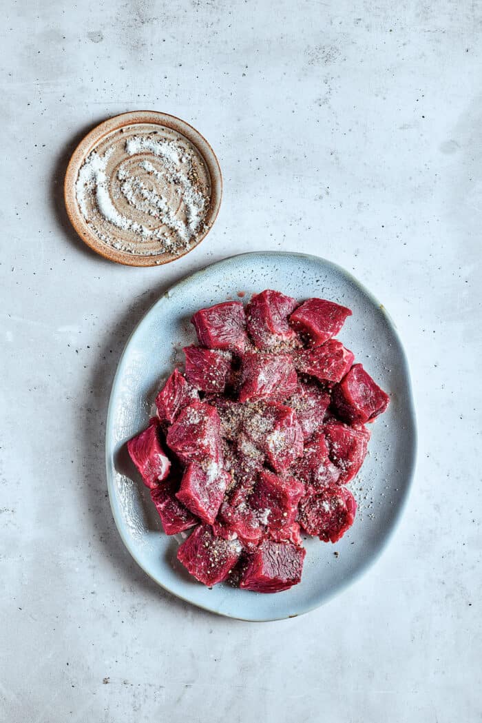 Seasoning the steak bites.