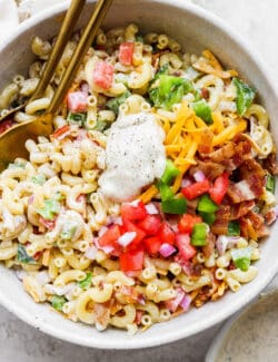 Mixing vegetables and macaroni together in a bowl.