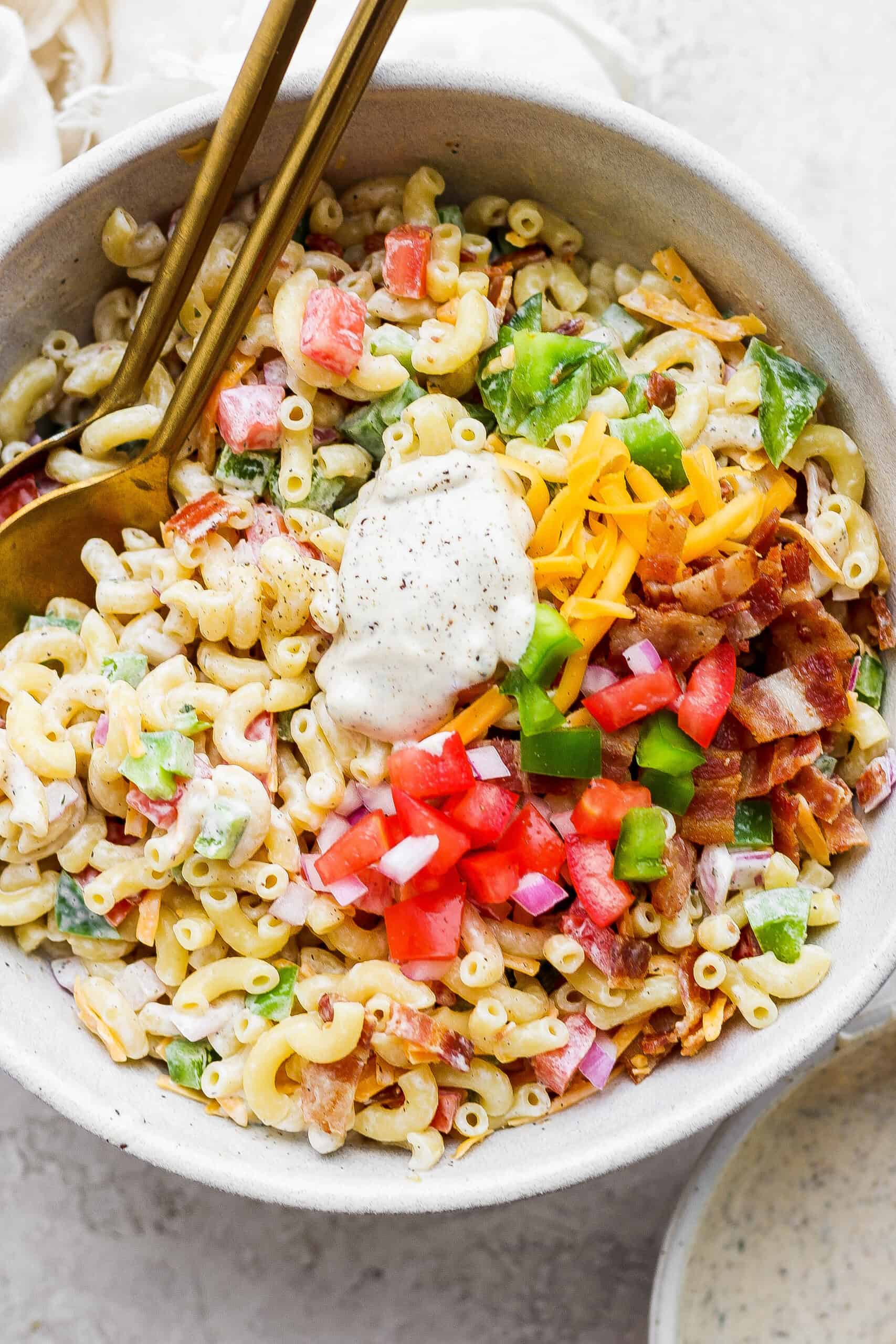 Mixing vegetables and macaroni together in a bowl.