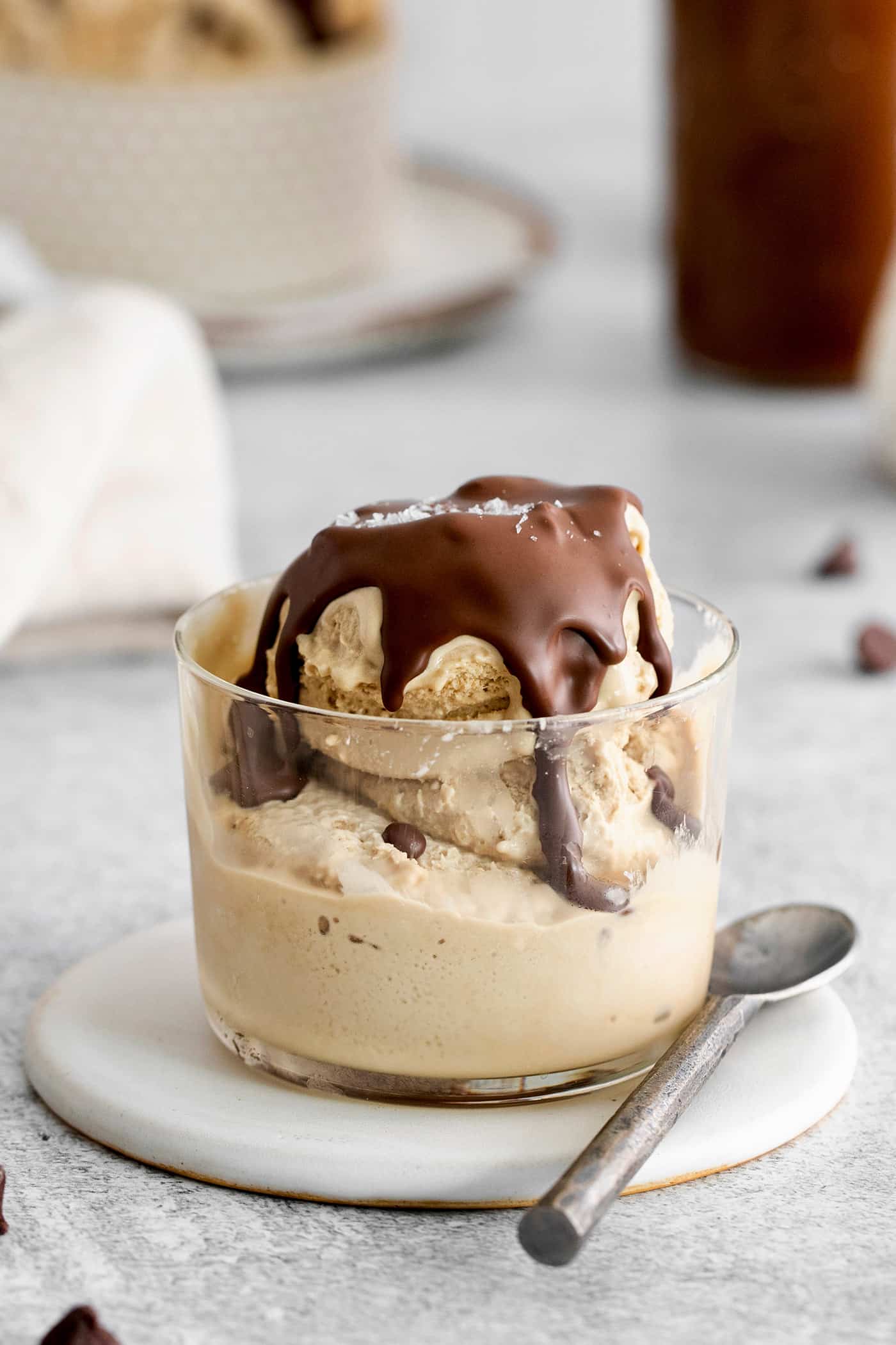 A clear bowl of ice cream topped with chocolate magic shell.