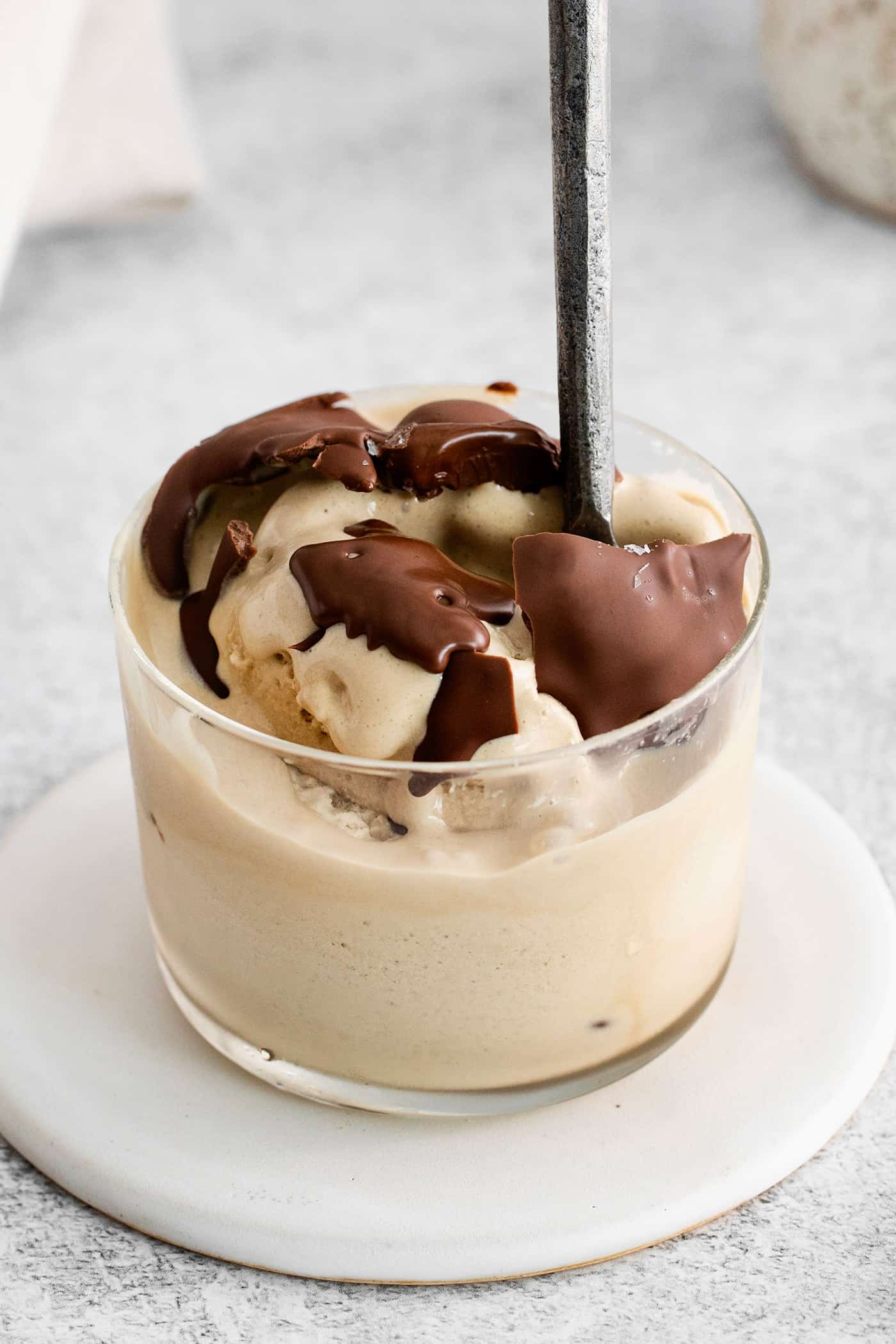 A bowl of ice cream topped with magic shell and a spoon.