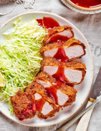 Pork katsu with shredded cabbage and lemon.