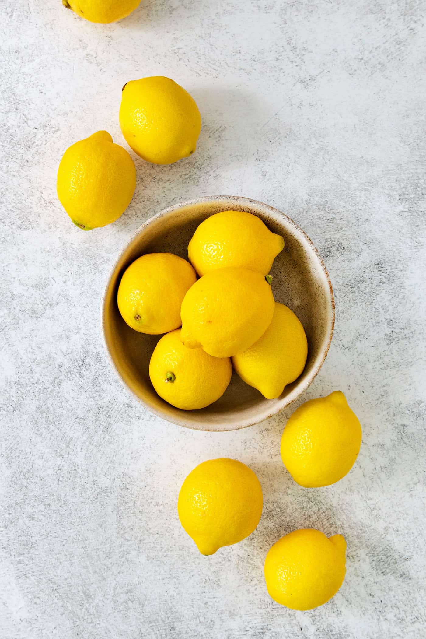 A bowl of lemons with lemons next to it.