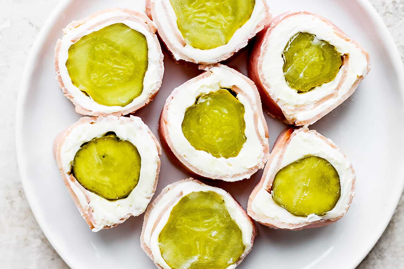 Pickle roll up are shown on a plate.