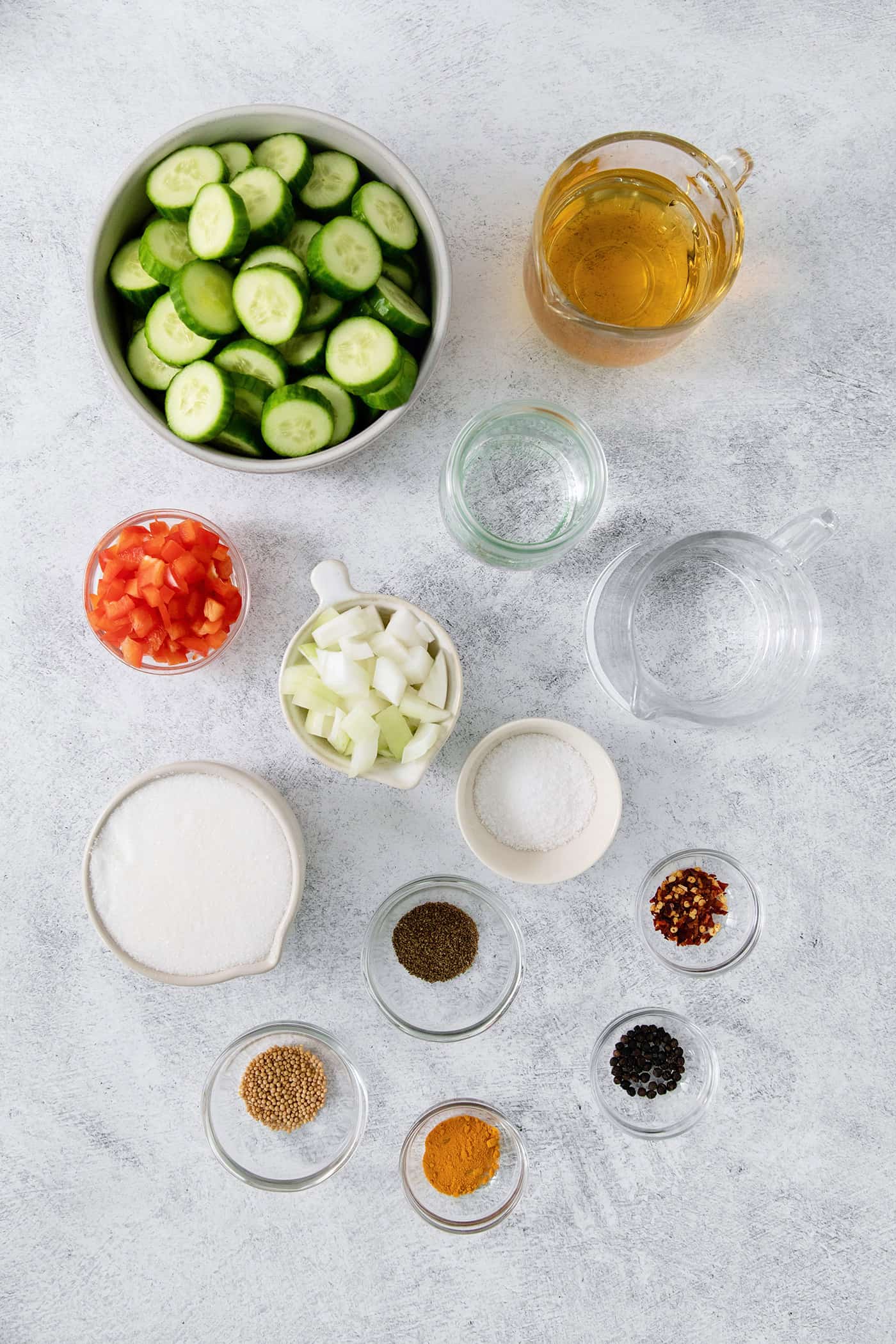 Ingredients needed for sweet and spicy pickles: cucumbers, bell pepper, onions, mustard and celery seeds, sugar, water.