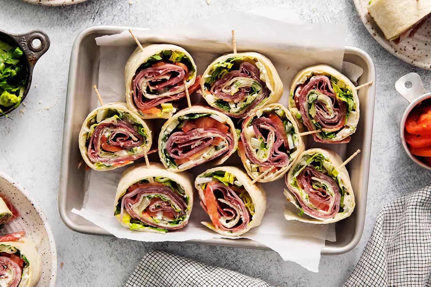 A tray of cut up Italian pinwheel sandwiches.