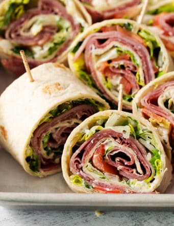 A tray of cut up Italian pinwheel sandwiches.