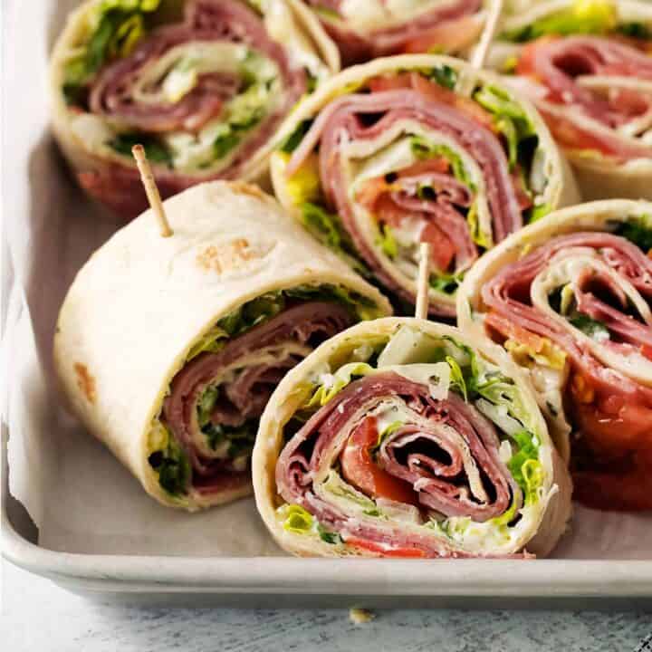 A tray of cut up Italian pinwheel sandwiches.