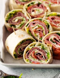 A tray of cut up Italian pinwheel sandwiches.