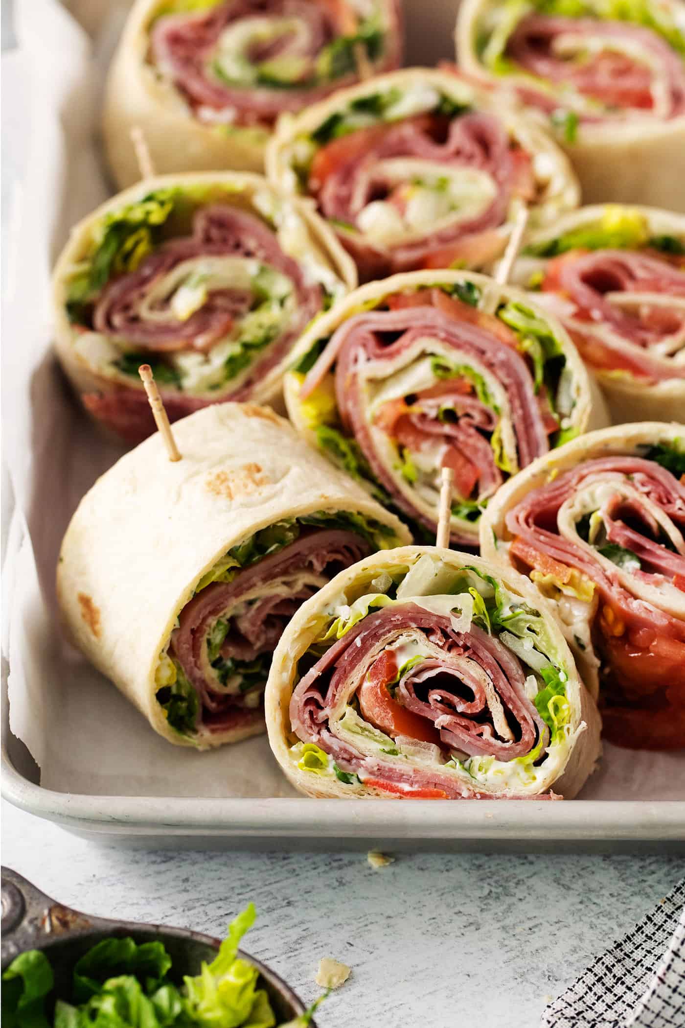 A tray of cut up Italian pinwheel sandwiches.