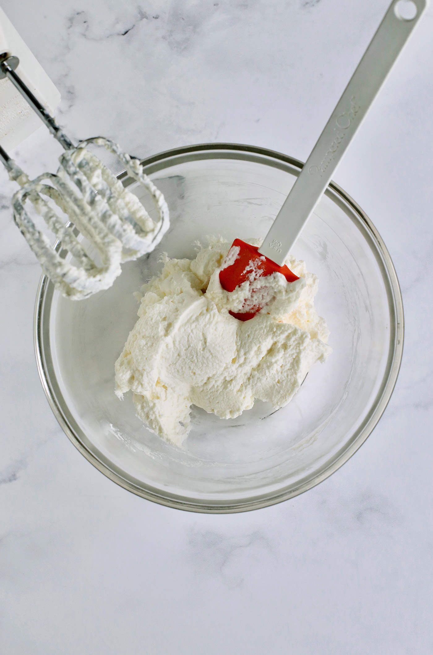 a clear bowl of stiffly whipped cream