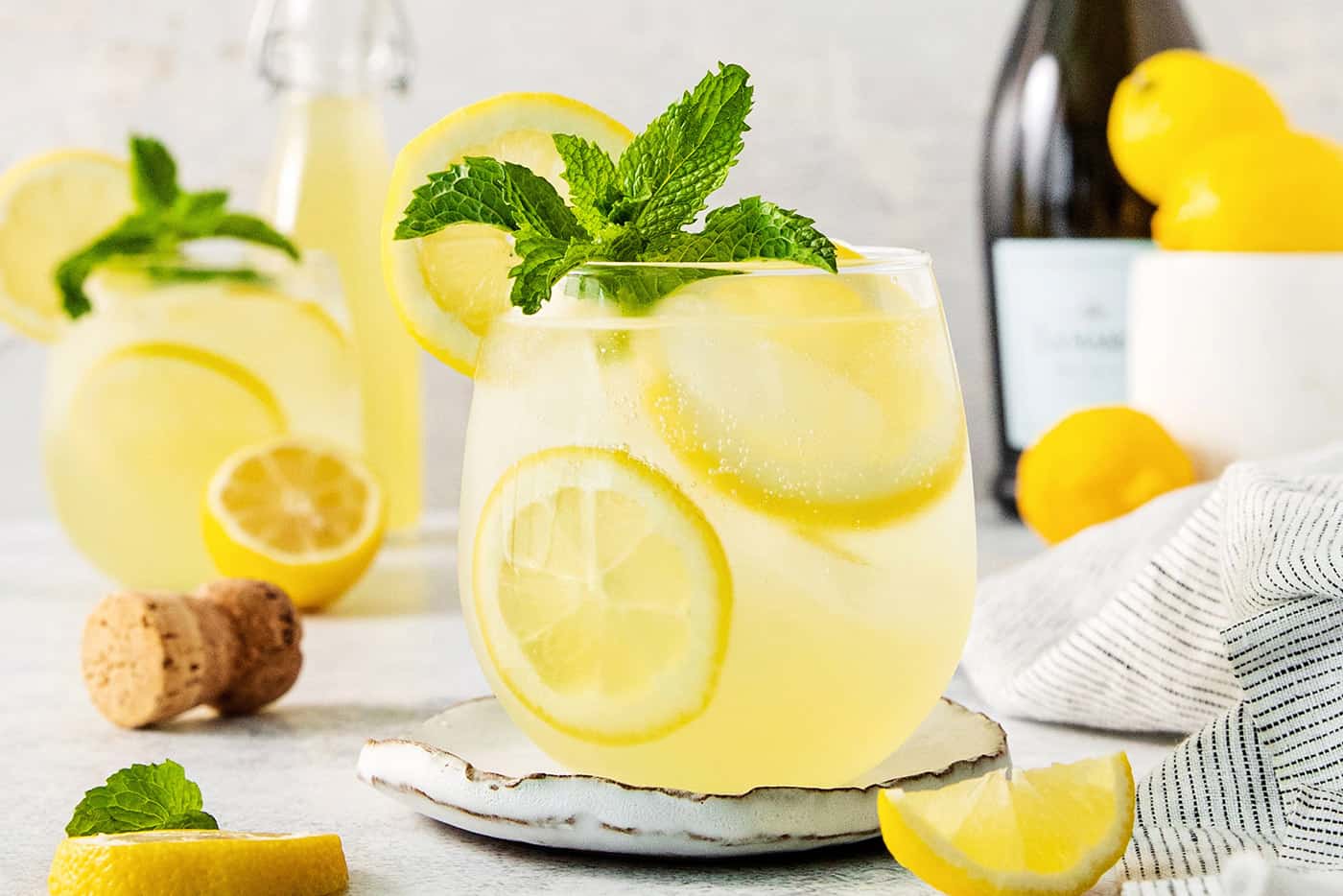 A glass of limoncello spritz garnished with mint.