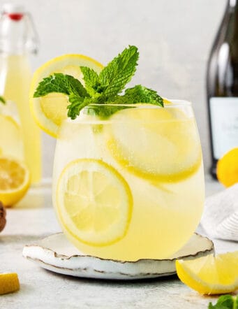 A glass of limoncello spritz garnished with mint.