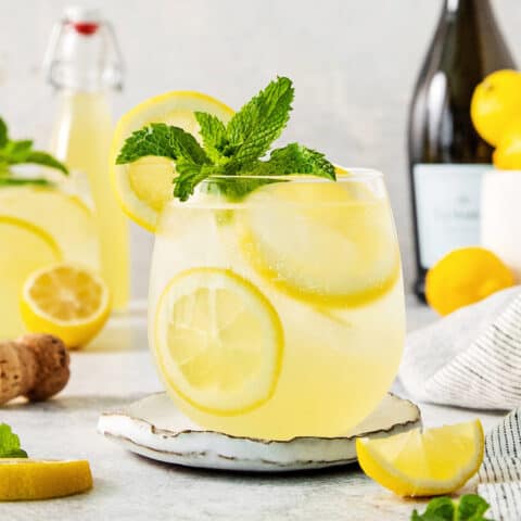 A glass of limoncello spritz garnished with mint.