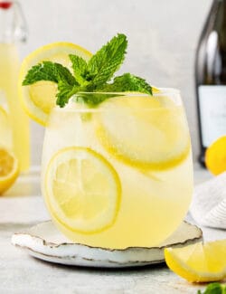 A glass of limoncello spritz garnished with mint.