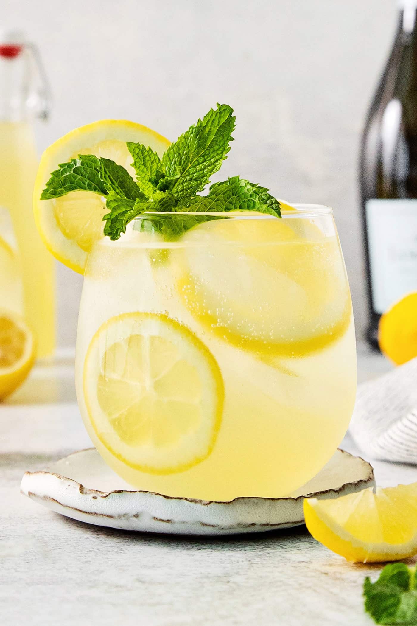 A glass of limoncello spritz garnished with mint.