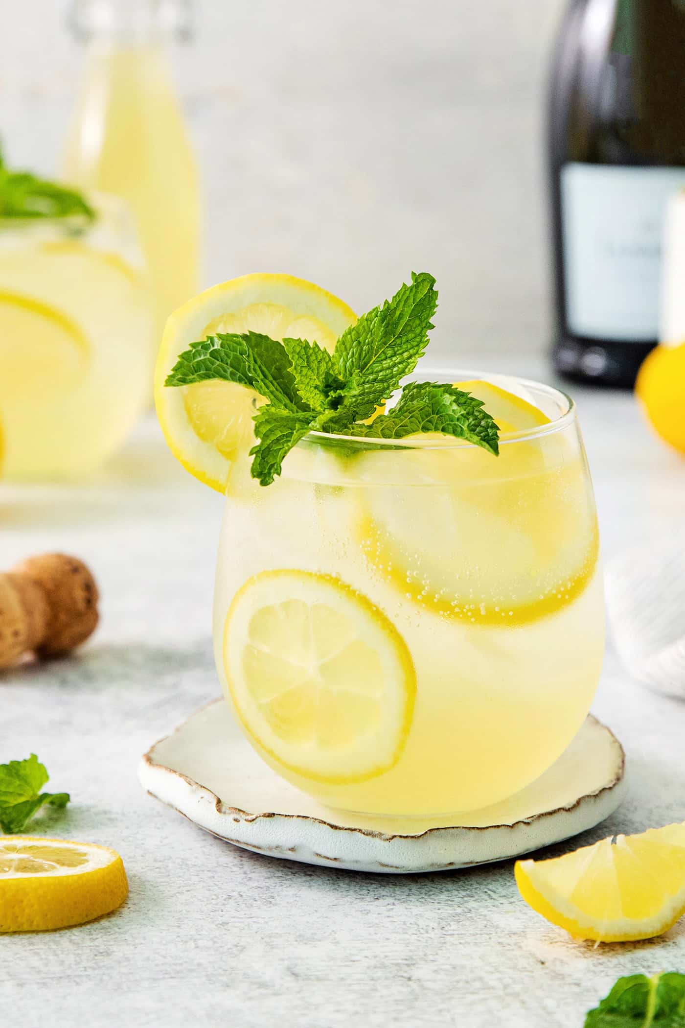 A glass of limoncello spritz garnished with mint.