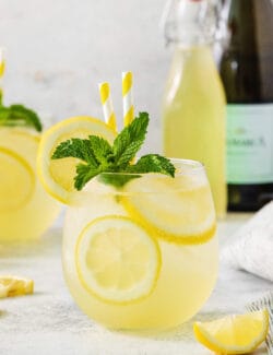 A glass of limoncello spritz garnished with mint.