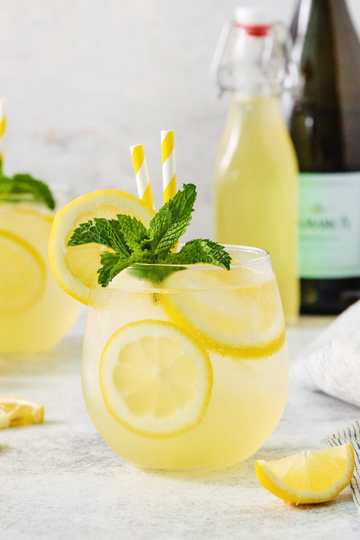 A glass of limoncello spritz garnished with mint.