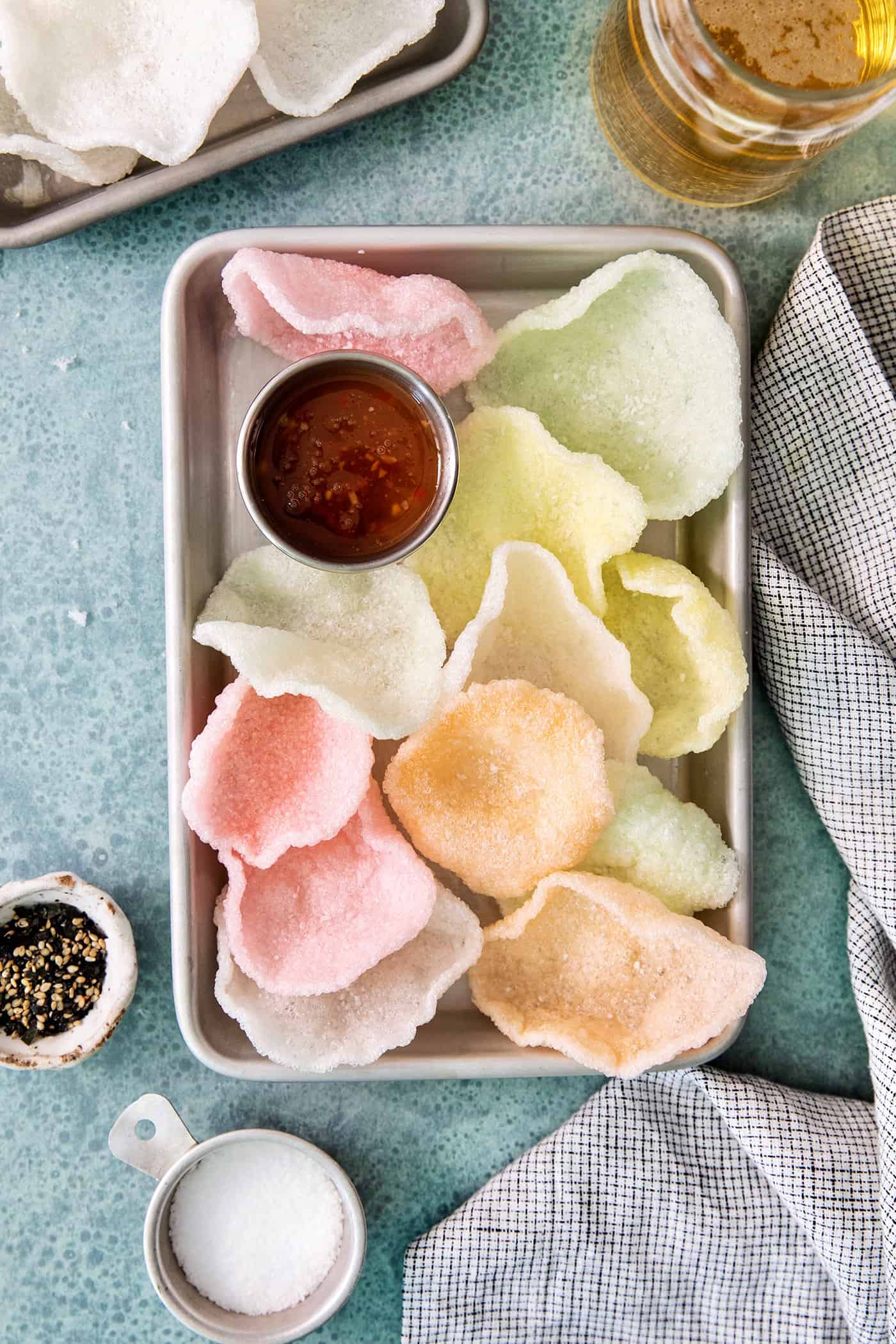 A tray of multicolored shrimp chips and sauce.