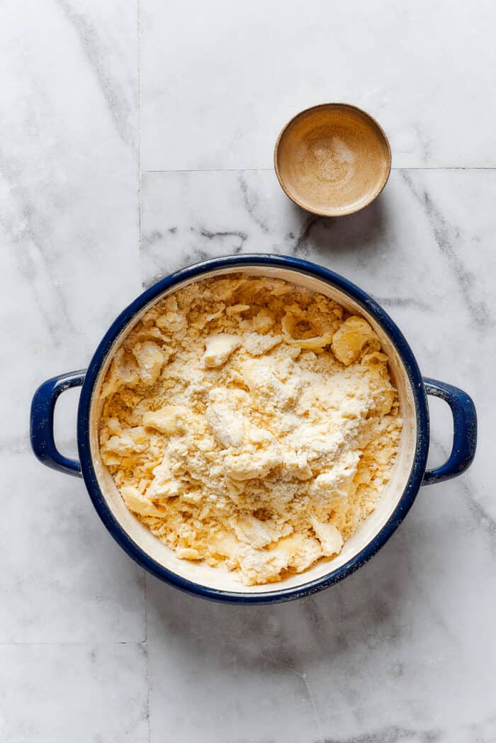 Butter is crumbled into flour for pie dough.