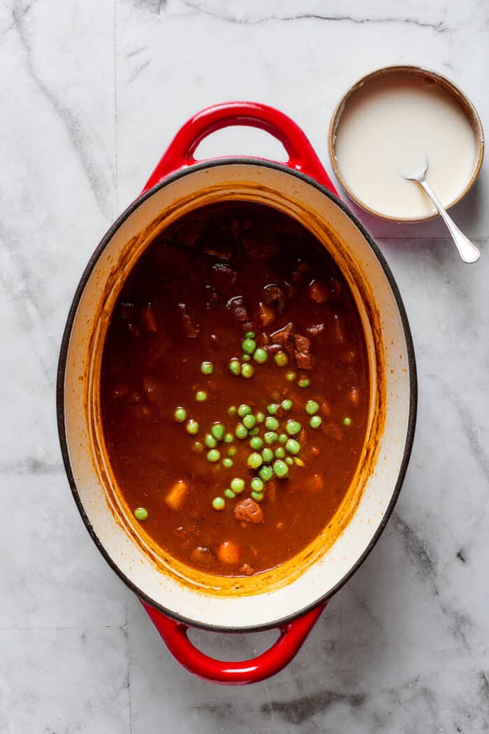 Peas are added to a pot of pot pie filling.