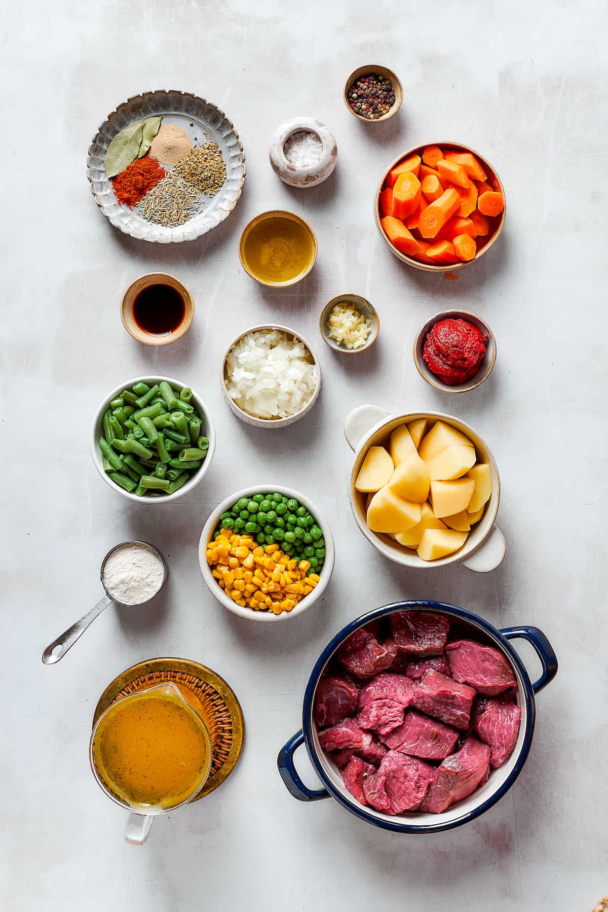 Ingredients for Mulligan stew are shown: stew meat, olive oil, peas, carrots, green beans, salt, garlic, onion, tomato paste, and beef broth.