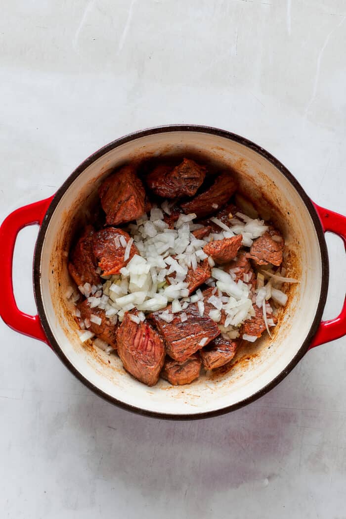 Onion is sprinkled on top of meat for Mulligan stew.