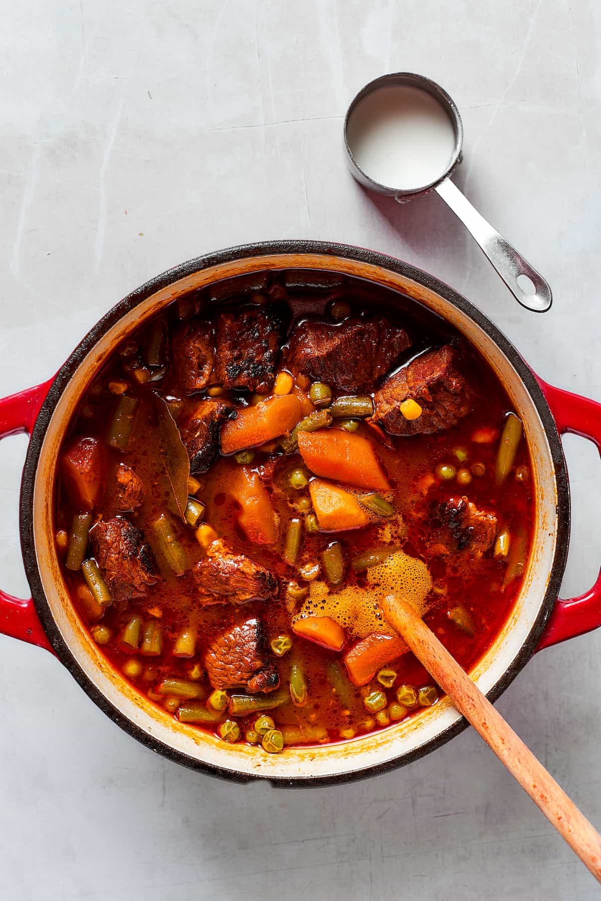 A wooden spoon stirs a pot of Mulligan stew.