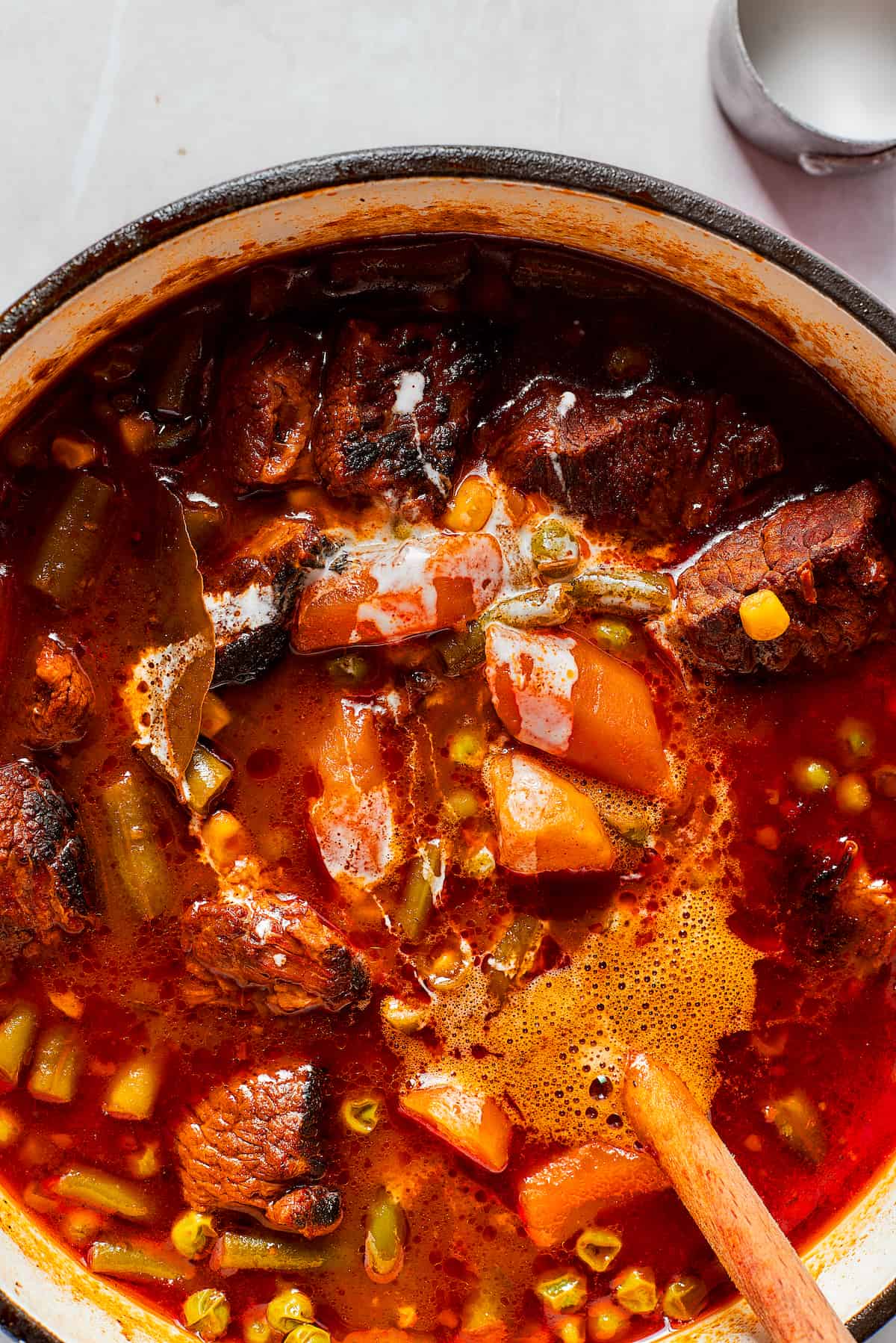 A wooden spoon stirs a pot of Mulligan stew.