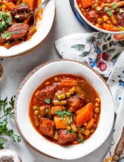 Bowls of Mulligan stew are shown on a flowered tablecloth.