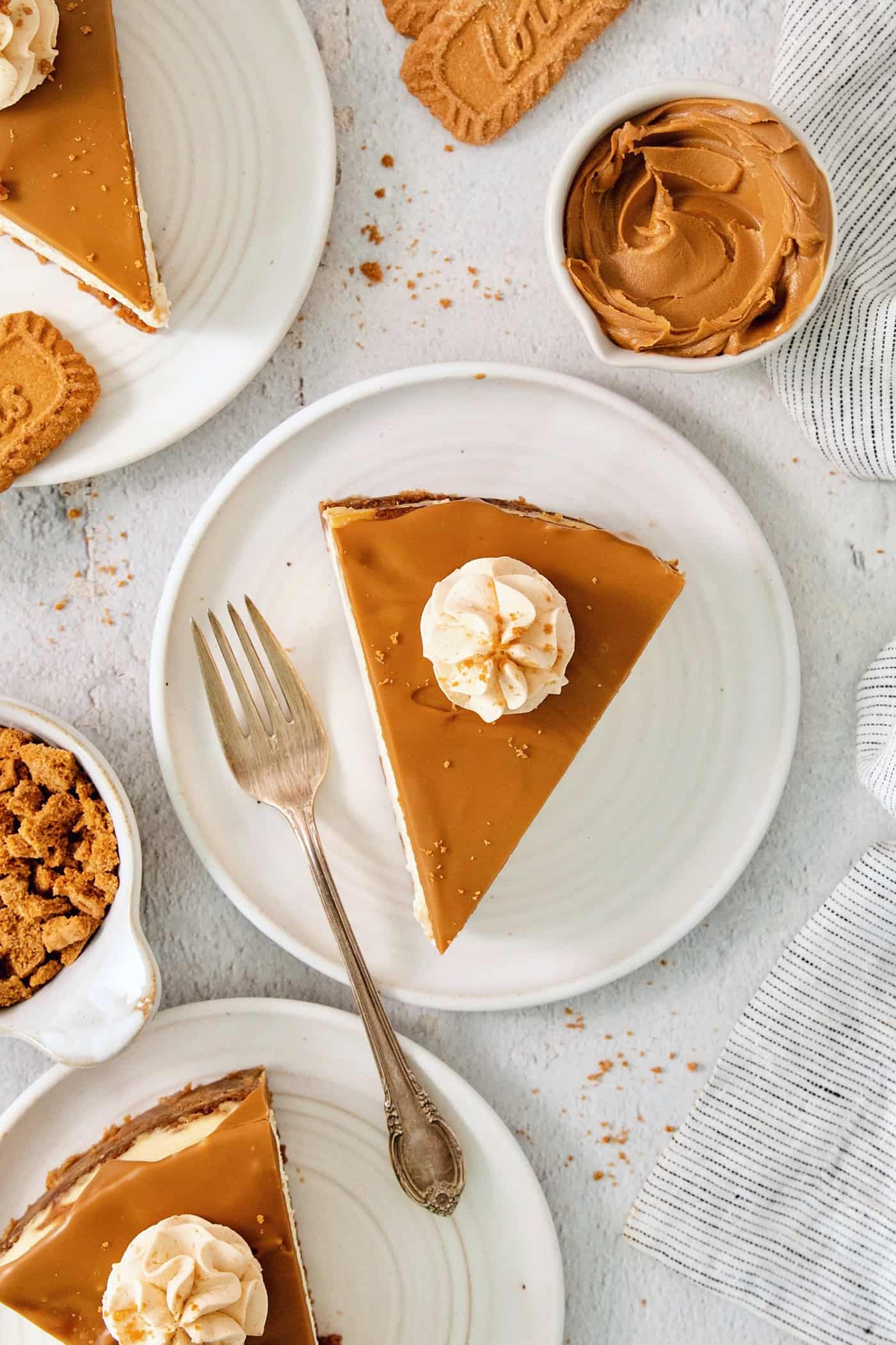 Slices of biscoff cheesecake are shown on white plates.